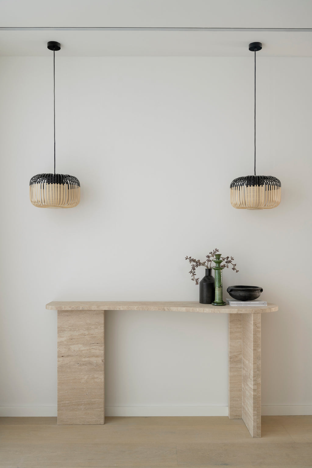 Full picture of the console with plant and bowl decor. Creamy beige travertine stone with rectangle bases and a curved top