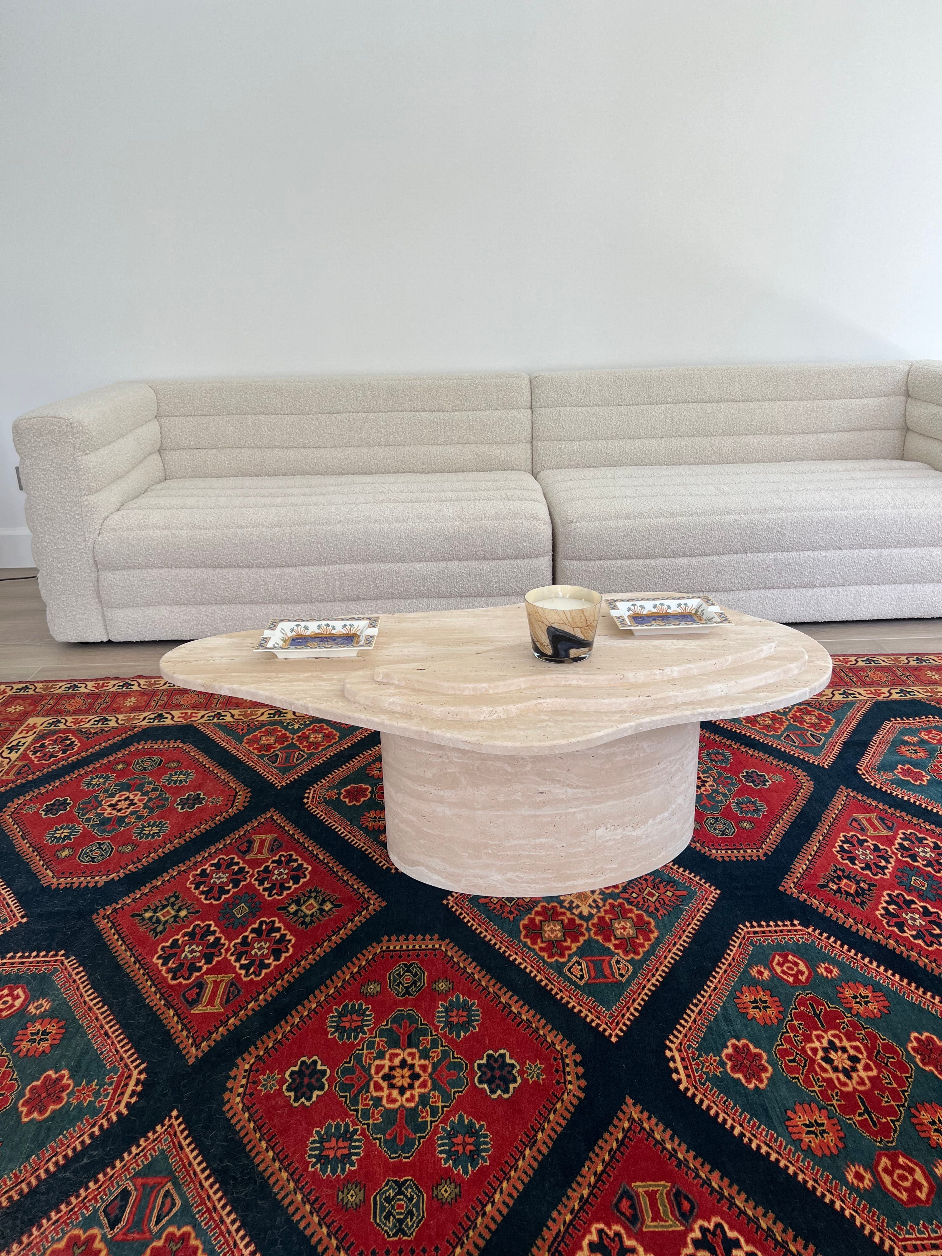 Side view of oval cylinder base organic shape top travertine coffee table.