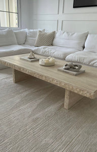 Stylish rough edged travertine stone coffee table in light beige stone.