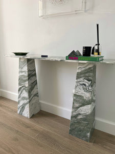 Green and white wavy marble console with a rectangle top and tapered legs.