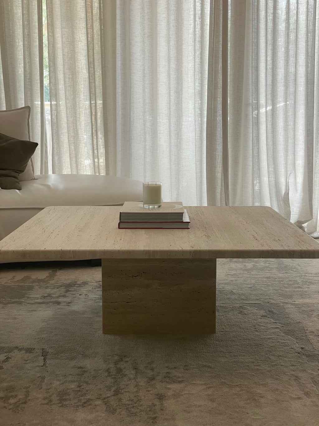 Square travertine coffee table with cube base in natural finish.