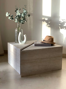 Triangle coffee tables arranged in a cube shape, decor items hat, book and stems.