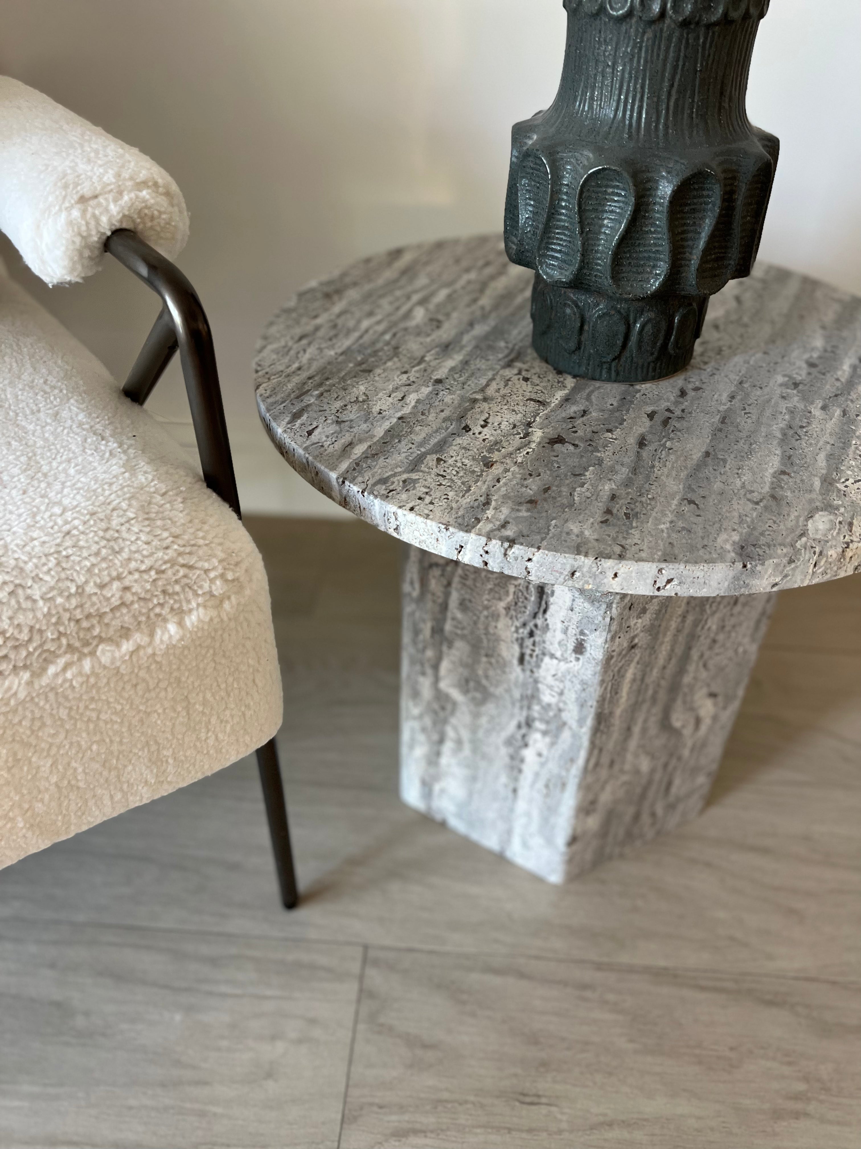 Small round silver travertine coffee table with hexagonal base.