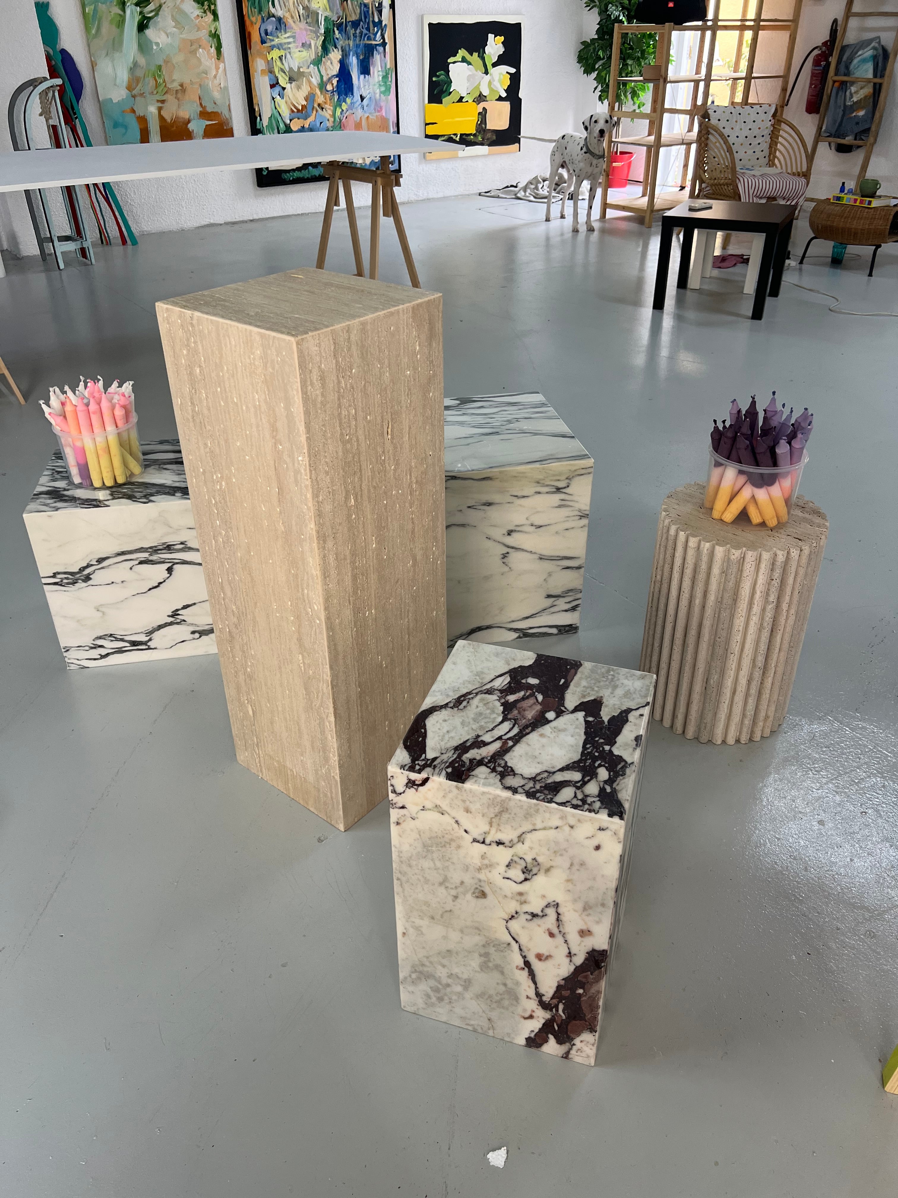 Display of different marble and travertine plinth tables in art gallery.